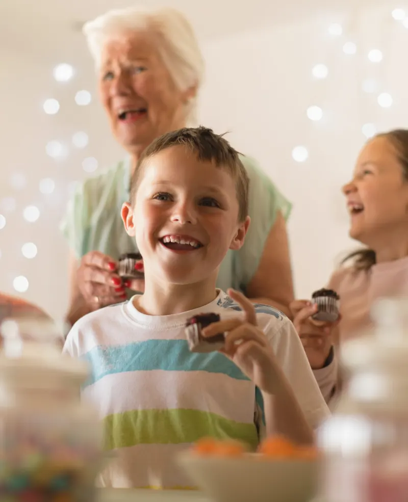 A grandmother laughing with her grandchildren at a family celebration